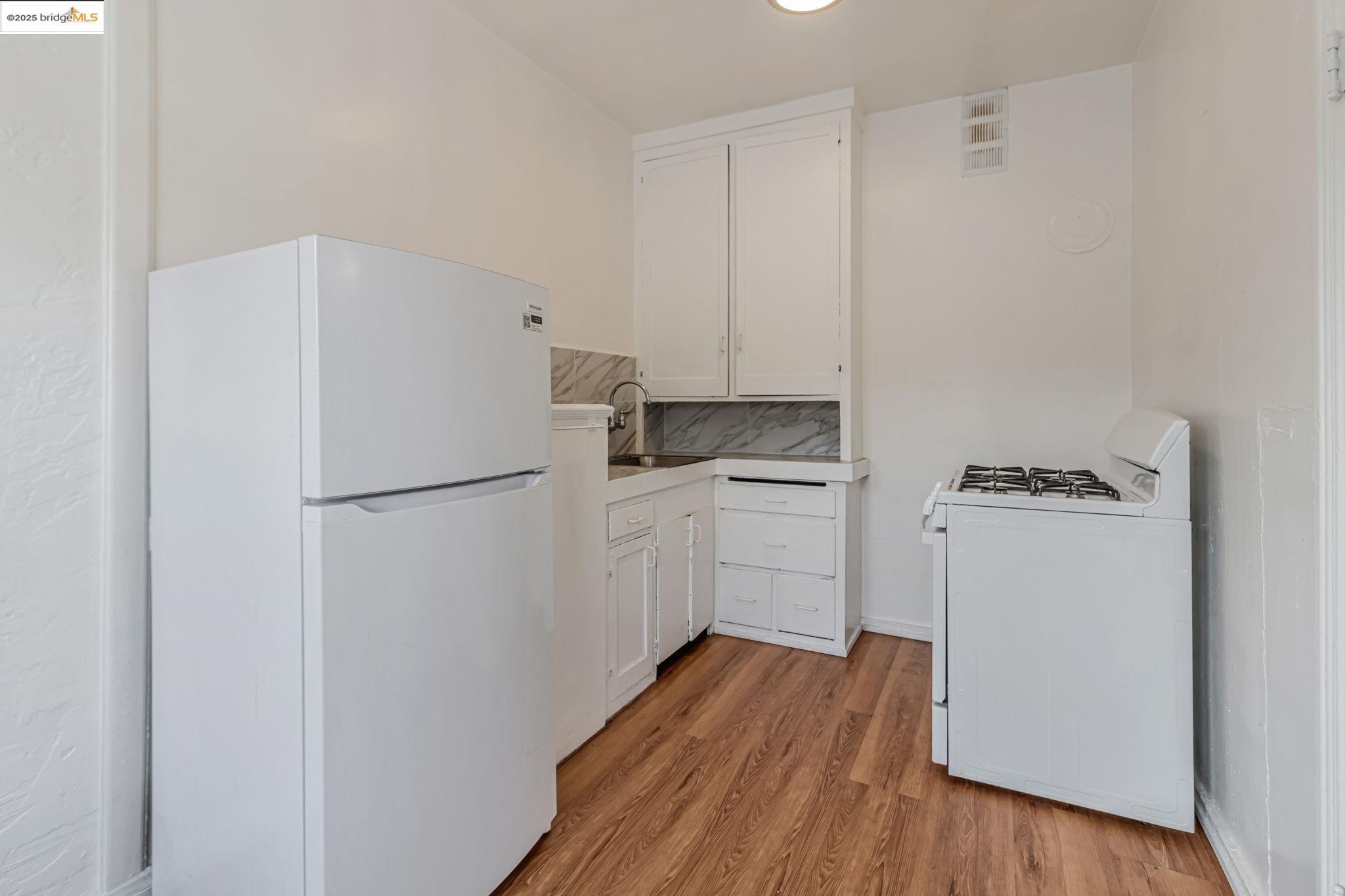 1360 Berkeley Way Berkeley, CA 94702 - Photo 19 of 35 a kitchen with a refrigerator a stove top oven and wooden floor