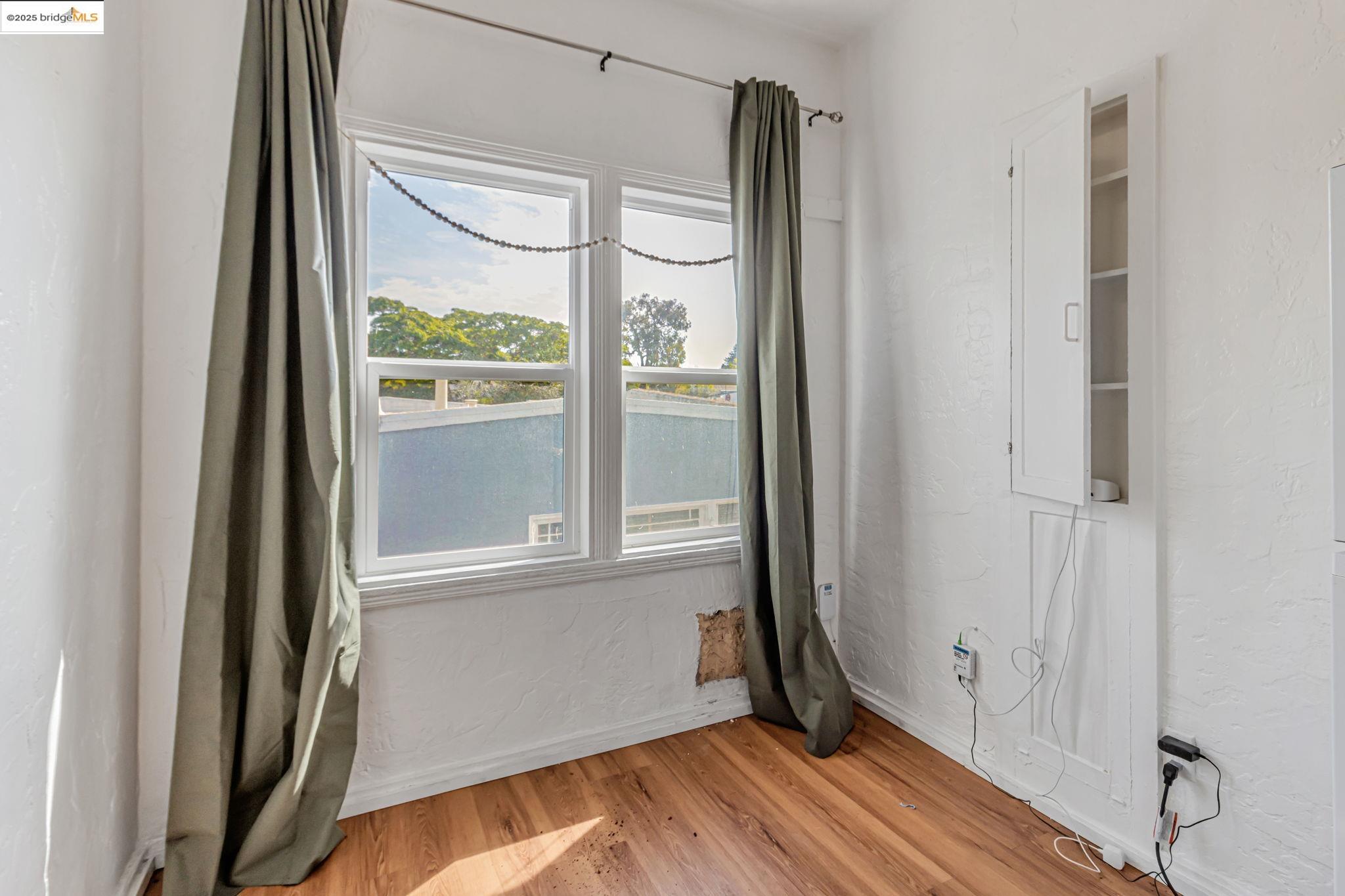 1360 Berkeley Way Berkeley, CA 94702 - Photo 20 of 35 a view of an empty room with wooden floor and a window