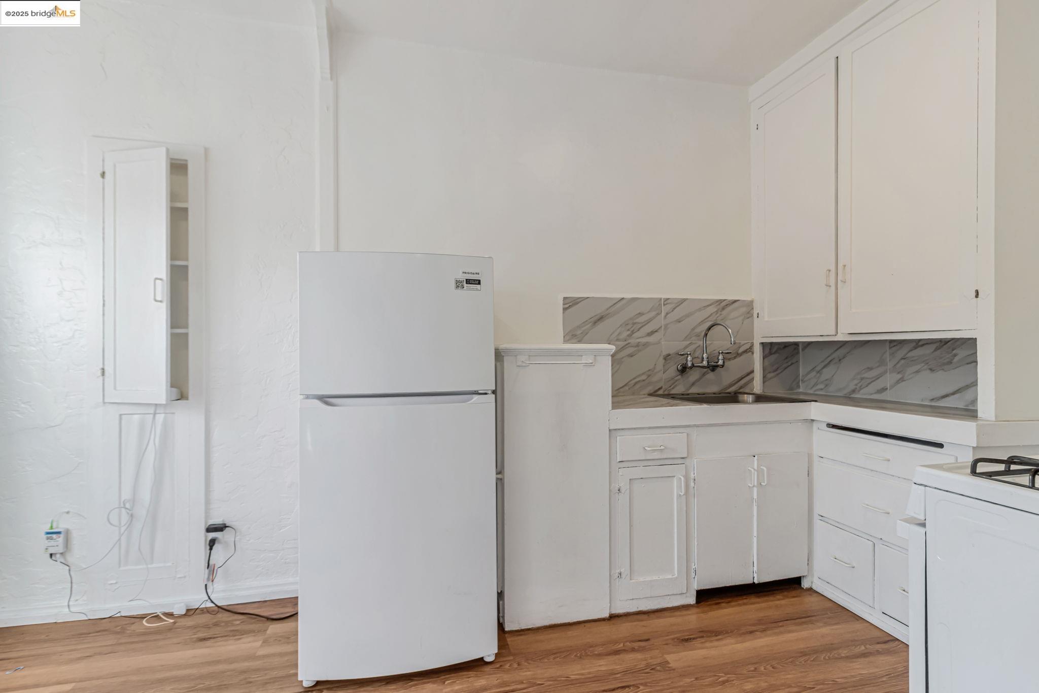 1360 Berkeley Way Berkeley, CA 94702 - Photo 4 of 35 a kitchen with stainless steel appliances white cabinets and a wooden floor