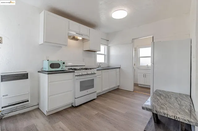 a kitchen with granite countertop white cabinets and white appliances