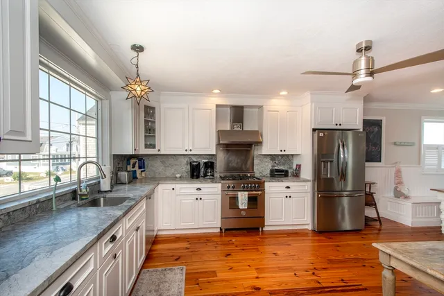 a kitchen with stainless steel appliances granite countertop a sink stove and refrigerator