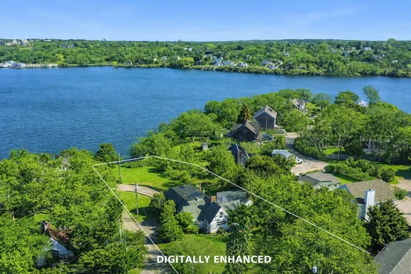 a view of a lake with a yard and large trees