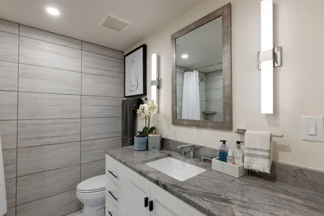 a tall yellow building with trees and couple of cars parked in front of it