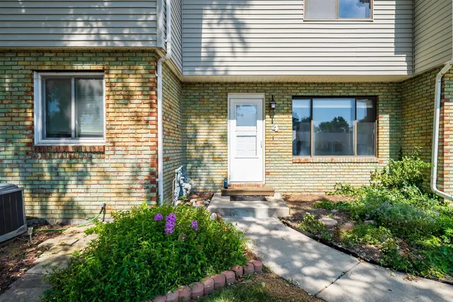 a view of brick house with potted plants