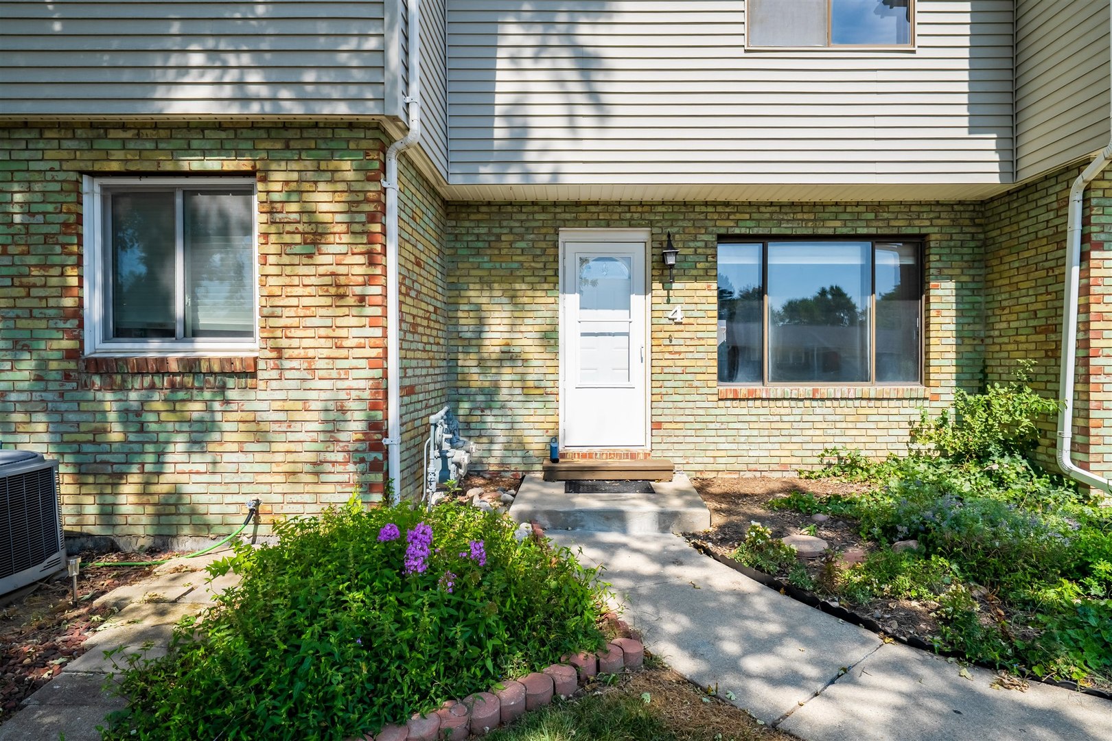 a view of brick house with potted plants