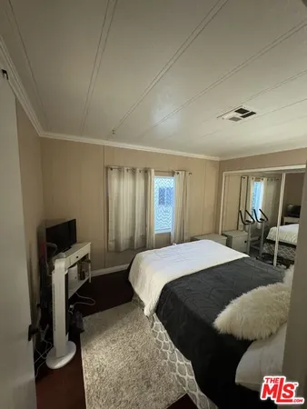 a bedroom with a bed and a mirror on dresser