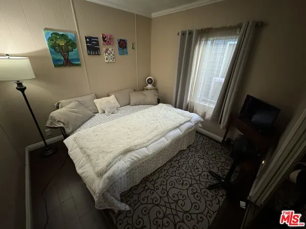 a bed sitting in a bedroom next to a window