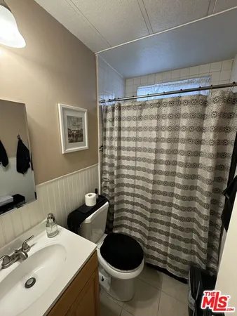 a bathroom with a sink a toilet and shower curtain