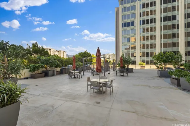 a view of a patio with dining table and chairs and potted plants