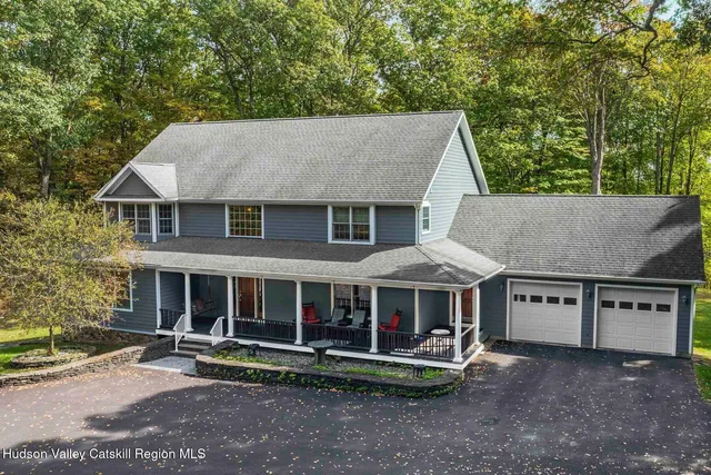 a front view of a house with a yard and potted plants