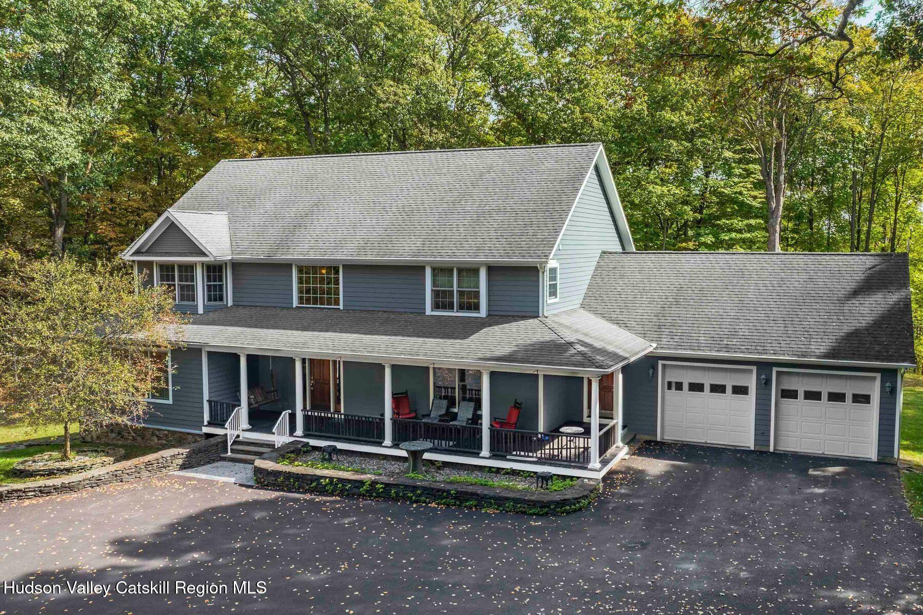 a view of a house with a yard and large tree
