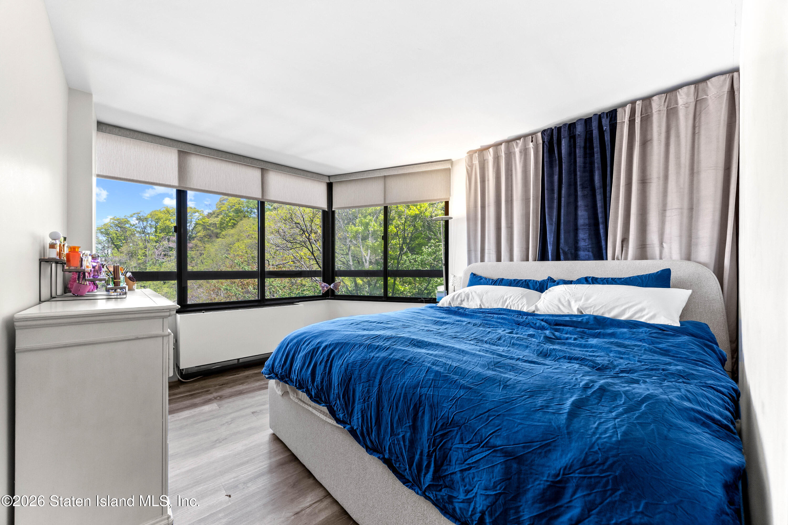 755 Narrows Road North, Unit 1014 Staten Island, NY 10304 - Photo 13 of 24 a bed sitting in a bedroom next to a large window