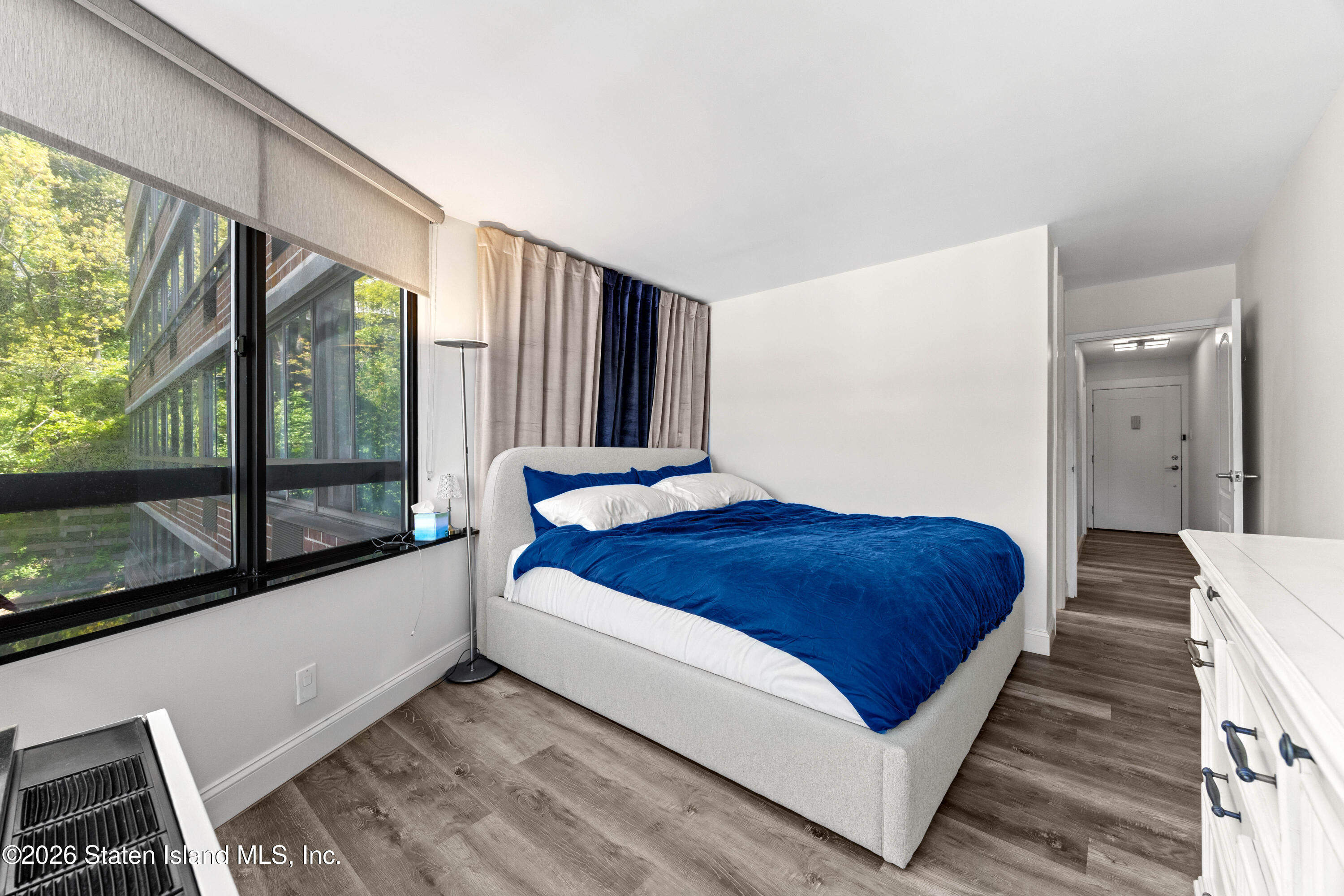 755 Narrows Road North, Unit 1014 Staten Island, NY 10304 - Photo 14 of 24 a bedroom with a large bed and a large window