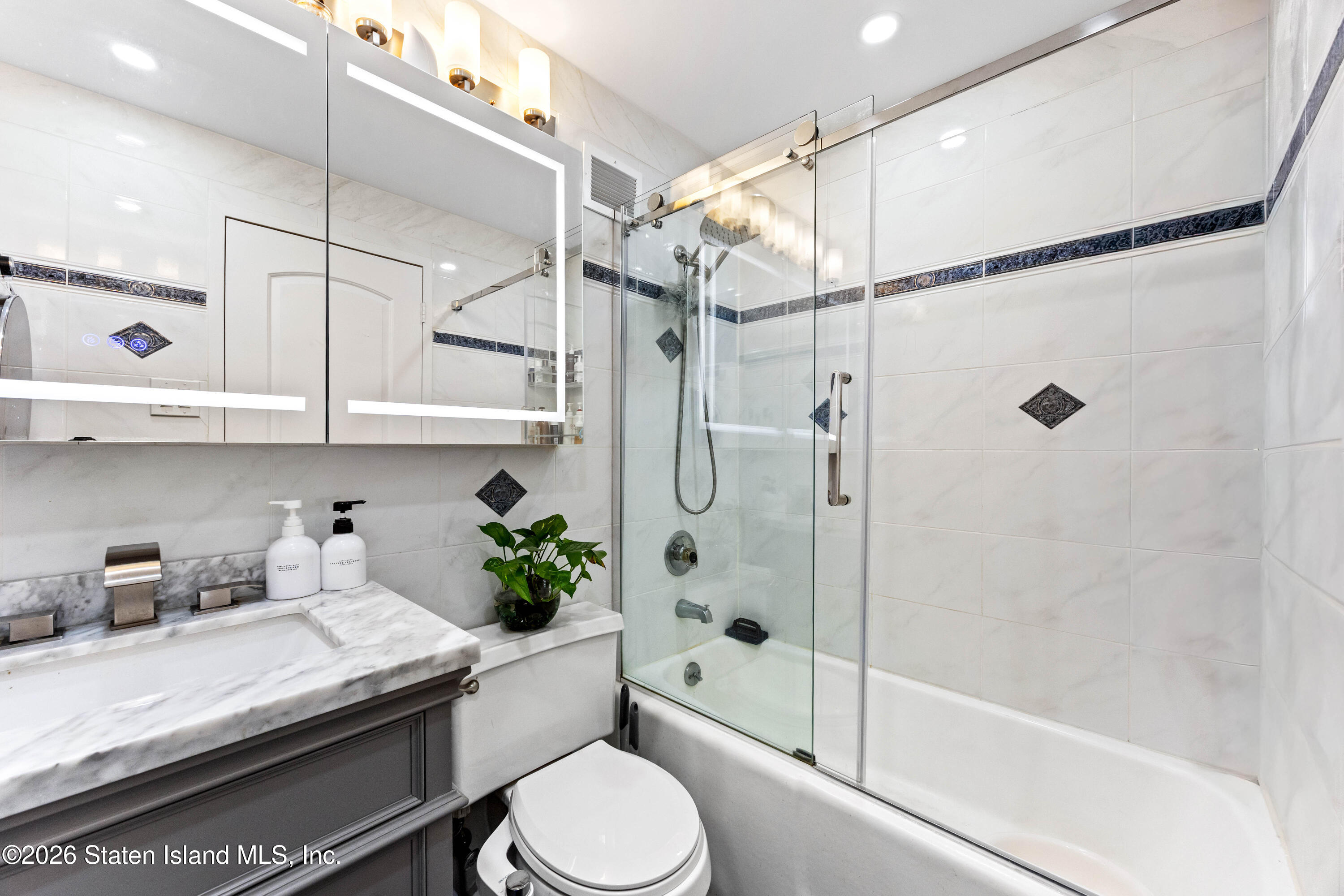 755 Narrows Road North, Unit 1014 Staten Island, NY 10304 - Photo 2 of 24 a bathroom with a sink a toilet and shower