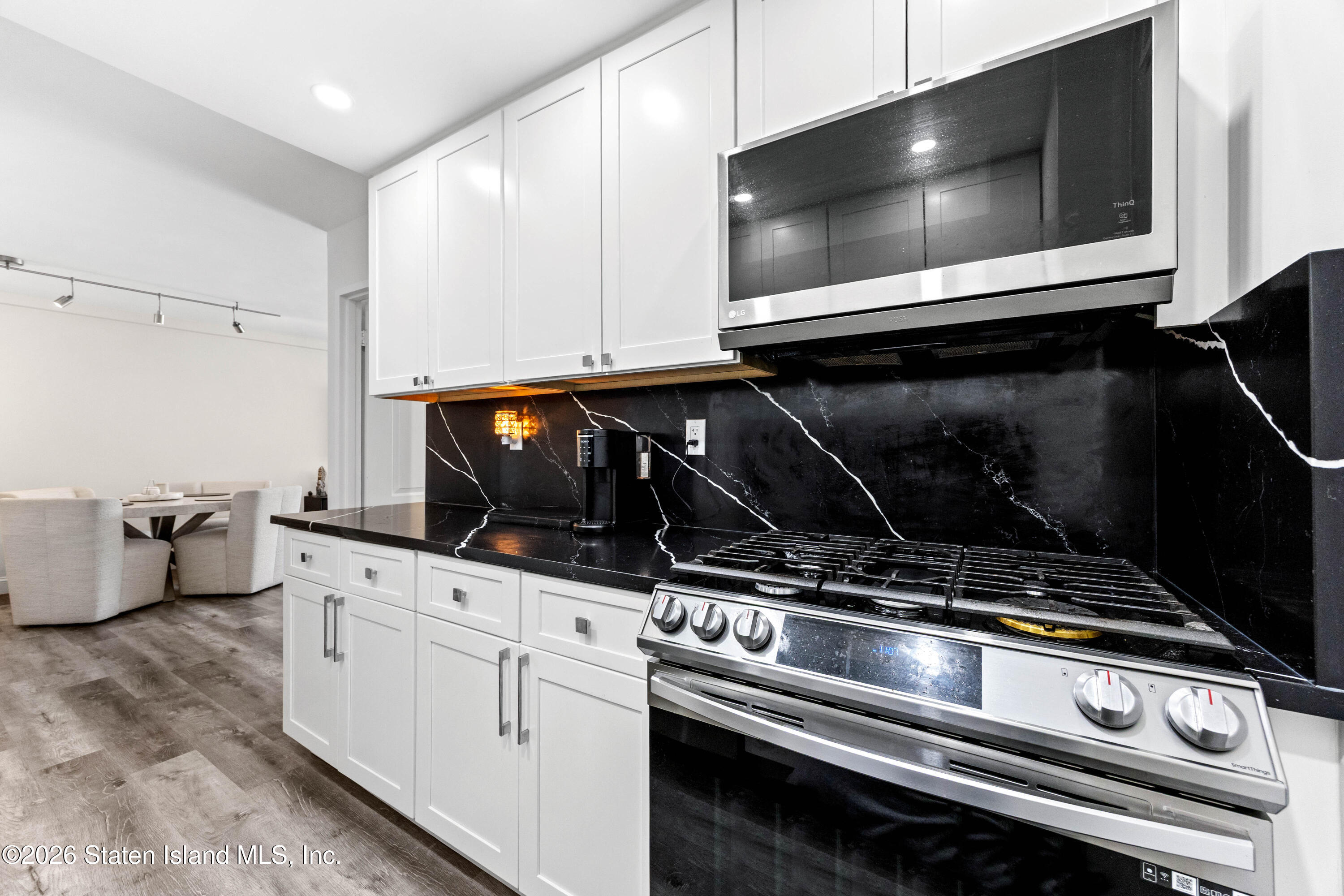755 Narrows Road North, Unit 1014 Staten Island, NY 10304 - Photo 6 of 24 a kitchen with white cabinets appliances and wooden floor