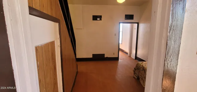 a view of a hallway with wooden floor and windows