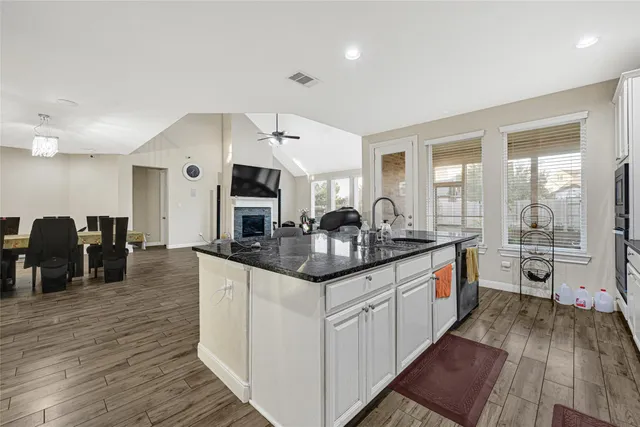 a kitchen with granite countertop a sink and cabinets