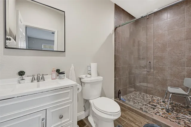 a bathroom with a sink a toilet and shower