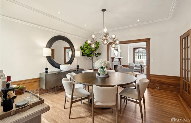 a dining room with furniture a chandelier and wooden floor