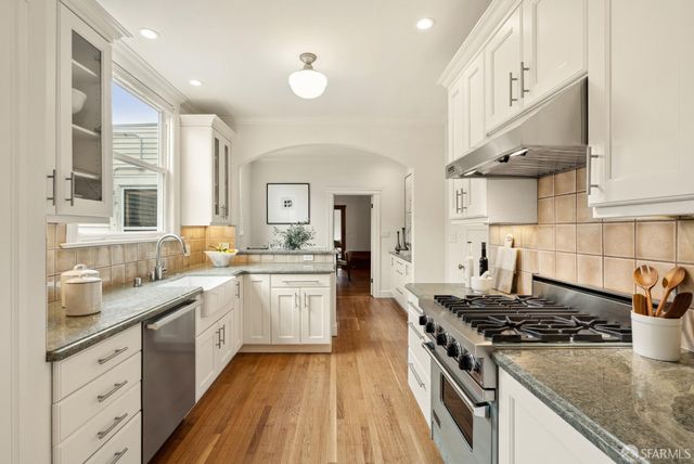 a kitchen with stainless steel appliances granite countertop a stove and a sink