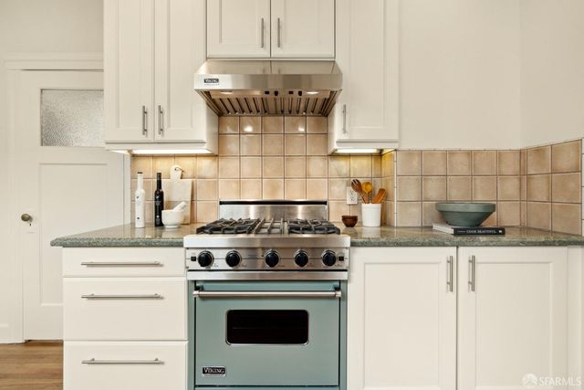 a stove top oven sitting inside of a kitchen