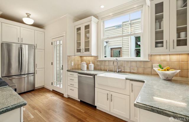 a kitchen with granite countertop a refrigerator and a sink