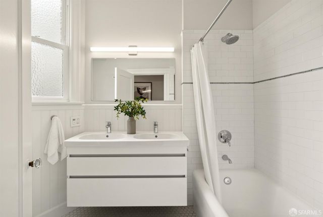 a bathroom with a sink and a mirror with bathtub