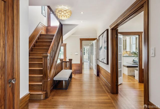 a view of a hallway with wooden floor and staircase