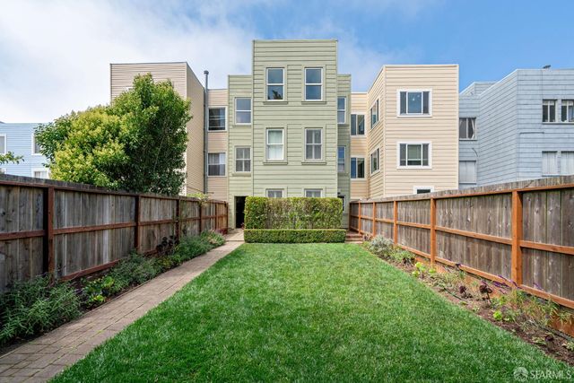 a view of backyard with potted plants and wooden fence