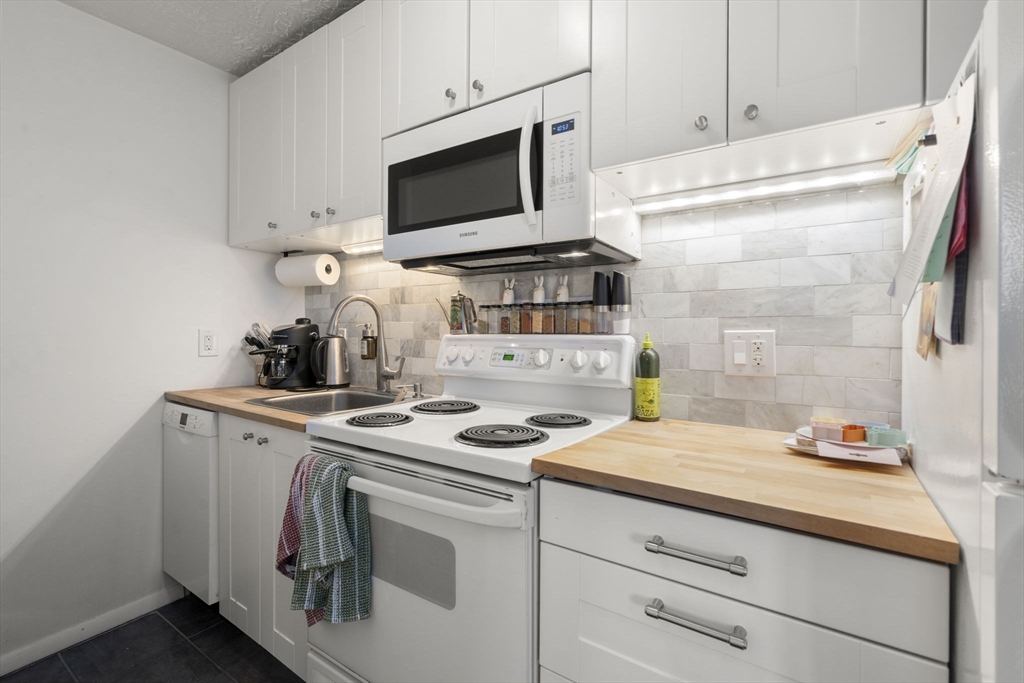 328 Commercial Street, Unit 53 Boston, MA 02109 - Photo 6 of 14 a kitchen with a sink stove and white cabinets