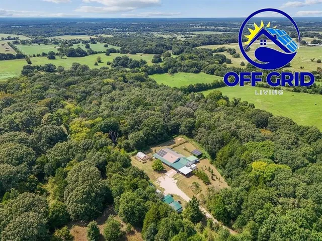 a sign that is on a bunch of plants and a tree