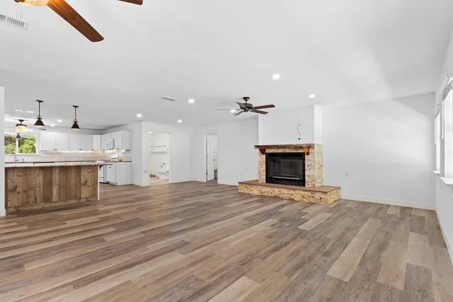 an empty room with wooden floor and fireplace