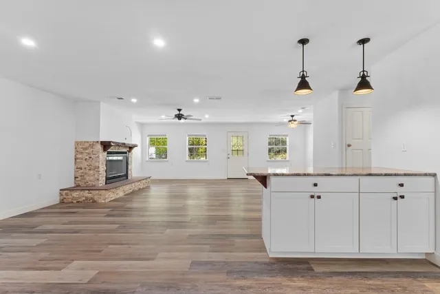 a view of an empty room with window and wooden floor