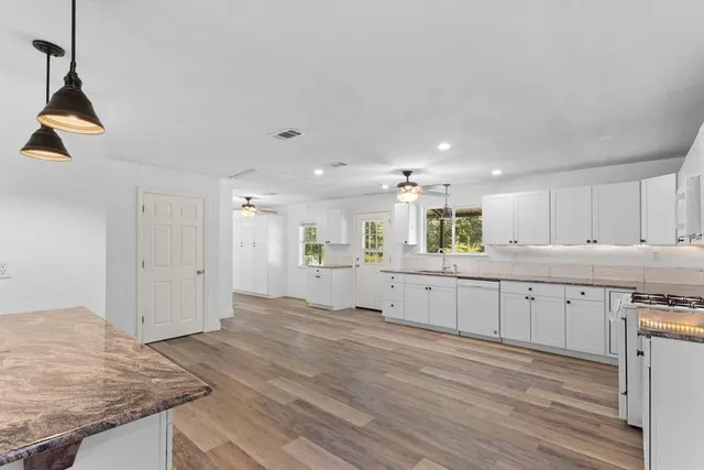 a large kitchen with kitchen island a sink stainless steel appliances and cabinets