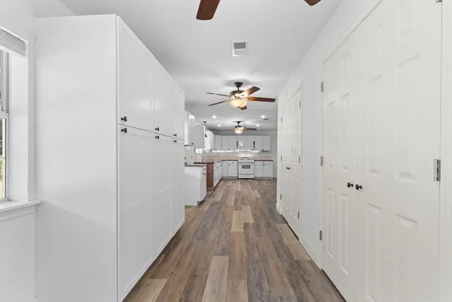 a view of a hallway with wooden floor