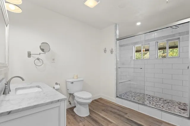 a bathroom with a granite countertop toilet a sink and mirror