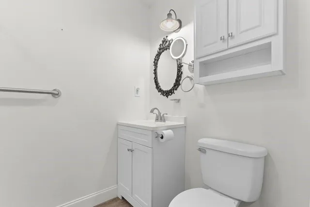 a bathroom with a toilet sink and mirror