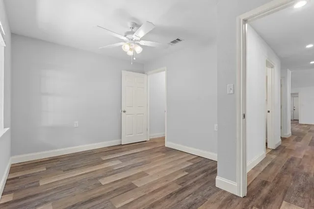 a view of an empty room with wooden floor