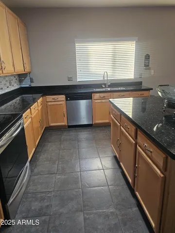 a kitchen with stainless steel appliances granite countertop a sink stove and cabinets