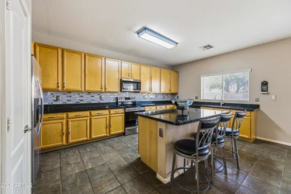 a kitchen with granite countertop sink stove and cabinets