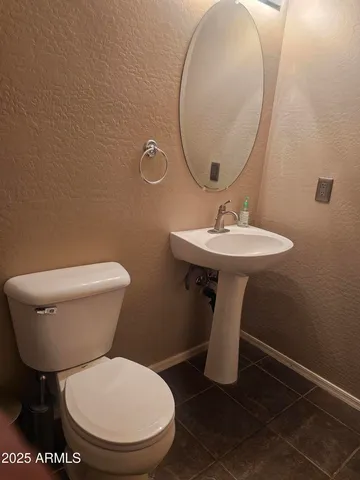 a bathroom with a toilet a sink and a mirror