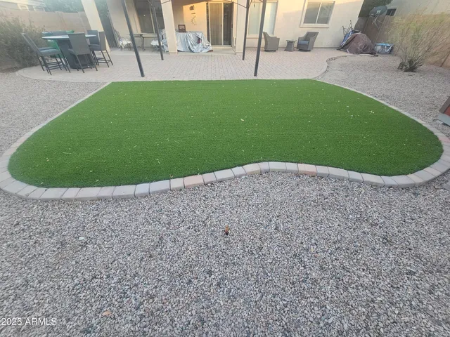 a view of a small house with a small yard and a large tree