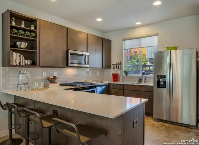 a kitchen with a sink a stove a refrigerator and cabinets