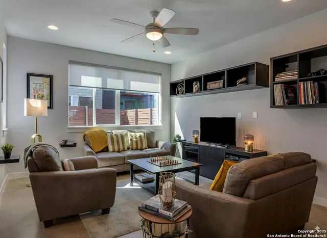 a living room with furniture a flat screen tv and a fireplace