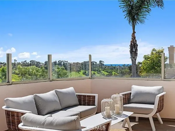 a roof deck with couches and potted plants