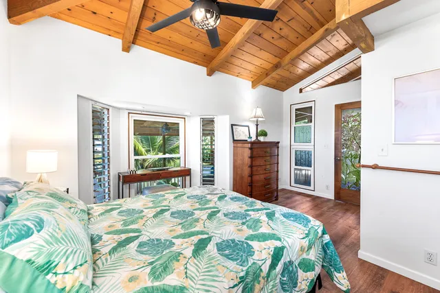 a bed sitting in a spacious bedroom next to a window