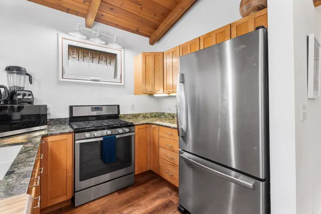 a kitchen with stainless steel appliances granite countertop a refrigerator and a stove top oven