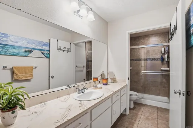 a bathroom with a granite countertop sink a mirror and a bathtub