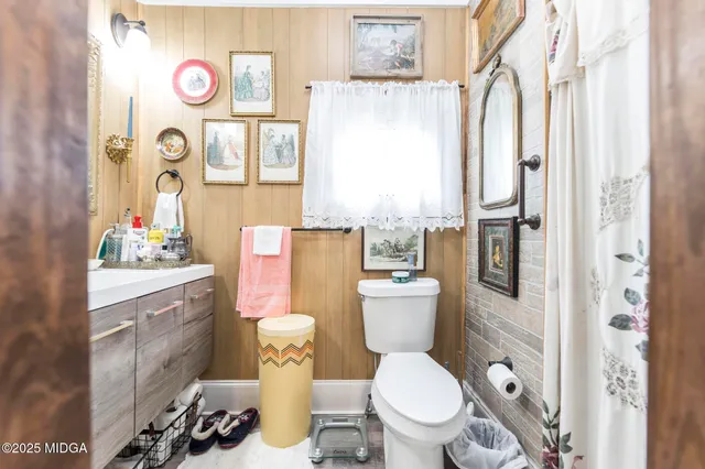 a white toilet sitting next to a bathroom sink and a window