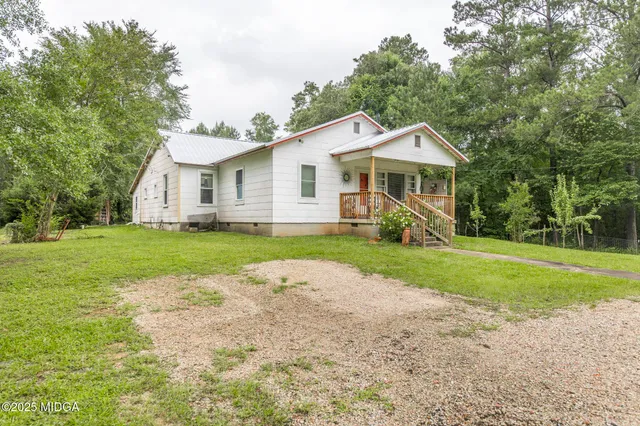 a view of a house with a yard and potted plants